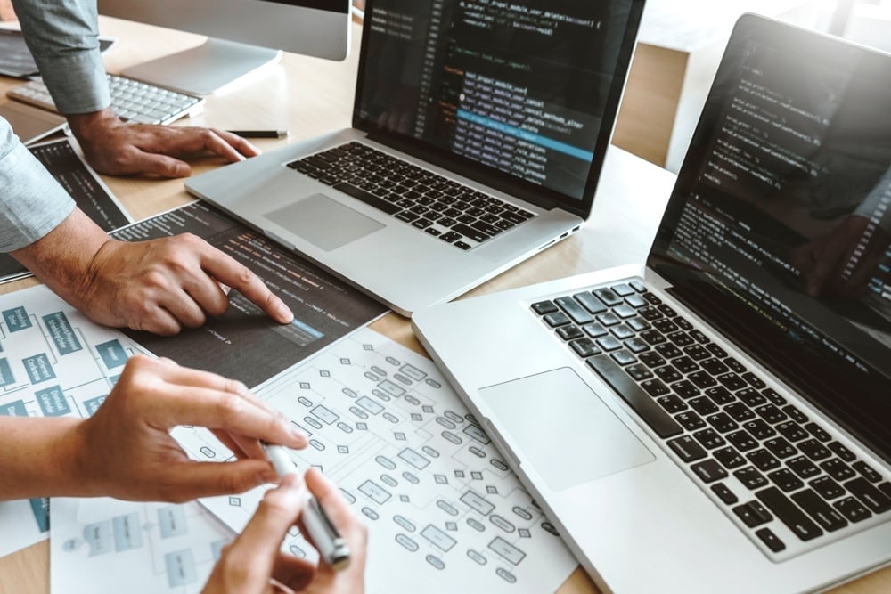 workers gesturing at desk and computer